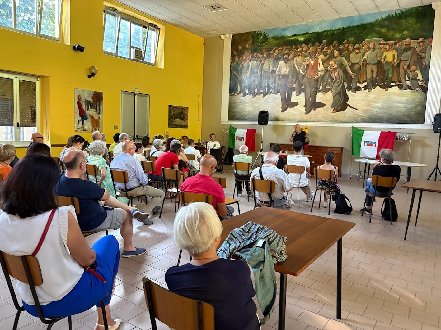 La sala del Circolo Way Assauto durante la serata, con il pubblico e le bandiere ANPI