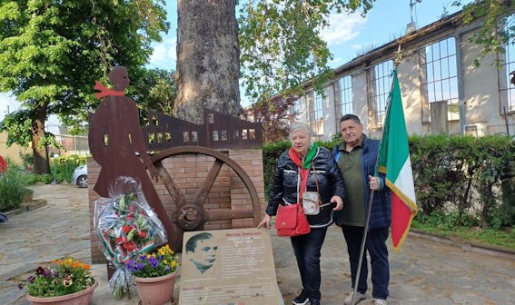 La scultura e la targa dedicate a Remo Dovano con i fiori, accanto alla bandiera tricolore